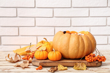 Wall Mural - Beautiful composition with tasty mulled wine in pumpkin on table near white brick wall