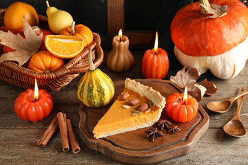 Wall Mural - Board with piece of delicious pumpkin tart and burning candles on wooden table