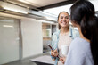 © Austockphoto - Aboriginal woman smiling while looking at her colleague in an office