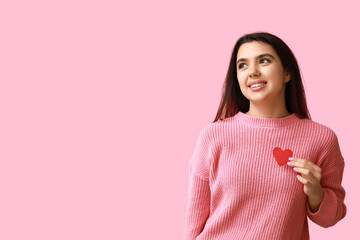 Wall Mural - Beautiful young girl with red paper heart on pink background. Valentine's Day celebration