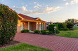 © Austockphoto - Last sunset light on brick house in quiet suburban area