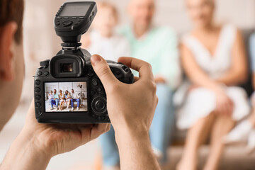 Canvas Print - Male photographer taking picture of big family in studio, closeup