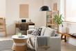 © Pixel-Shot - Interior of stylish living room with grey sofa, coffee table, workplace and shelving unit