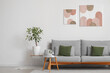 © Pixel-Shot - Interior of stylish living room with comfortable sofa, coffee table and pictures on white wall