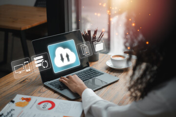 A person working on a laptop with cloud backup icons, symbolizing data security and storage solutions in a contemporary office setting.