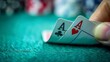 © nilanka - Playing cards on the table, a Close-up view of a poker game, hand holding pair of Aces, hearts, and spades ace cards on winning hand.