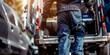© xartproduction - A man in a blue work uniform is walking out of a van