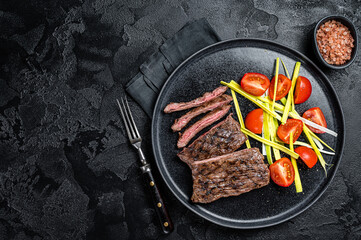 Wall Mural - Grilled arrachera Skirt steak with garnish.  Black background. Top view. Copy space