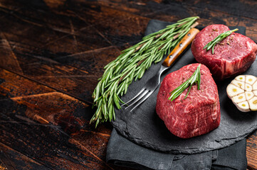 Wall Mural - Raw Fillet Mignon Beef steak with herbs and garlic, marble meat. Wooden background. Top view. Space for text