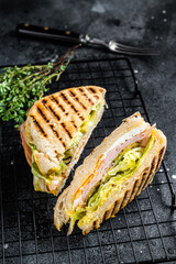 Wall Mural - Grilled panini with Prosciutto ham, salad and cheese. Black background. top view