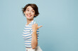 © ViDi Studio - Side view young smiling woman wears striped t-shirt casual clothes point thumb finger back aside on area mock up isolated on plain pastel light blue cyan background studio portrait. Lifestyle concept.
