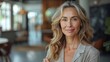 © Photolife   - portrait of a confident beautiful middle-aged Caucasian business woman in a business suit looking smiling at the camera while in the office