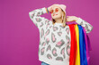 © ViDi Studio - Young happy lesbian woman wear pink animal clothes hold striped rainbow flag on shoulder look aside on area mockup isolated on plain purple background studio. Pride day June month love LGBTQ concept.