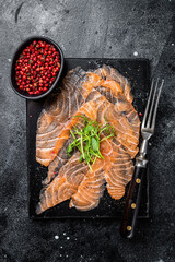 Wall Mural - Salmon carpaccio with microgreens on marble board. Black background. Top view