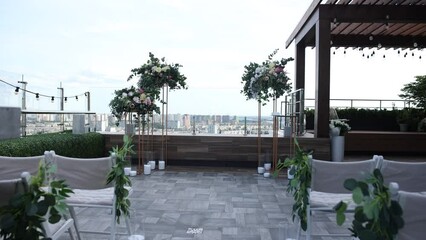 Poster - arch of a wedding ceremony made of flowers against the background of a big city