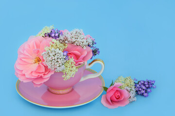 Wall Mural - Surreal rose, valerian, lavender and elder flower design in tea cup on blue. Fun food herbal medicine composition. Flowers have adaptogen relaxation health benefits.