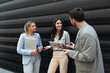 © Srdjan - Group of successful young business people, leaders in marketing and motivation, stand in front of office building and consult before a meeting with employees. HR communication in companies concept