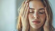 © Tida - Woman touching temples in stress or headache - Closeup of a young woman with her eyes closed touching her temples, showing signs of stress, fatigue or headache