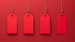 © Tida - Red tags hanging against a red background - Four blank red tags suspended against a matching red backdrop symbolizes sales, identity, and branding
