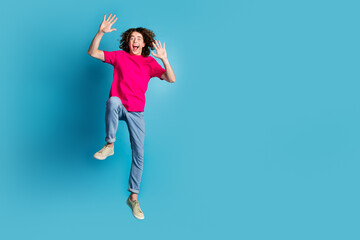 Poster - Full size photo of nice young man jump raise hands wear t-shirt isolated on blue color background