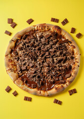 Wall Mural - whole Brazilian chocolate Pizza on Yellow Background