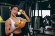 © Quality Stock Arts - Healthy women in Fitness Gym Body Care by Eating Mix Fruits and weight Training in Sport Club.