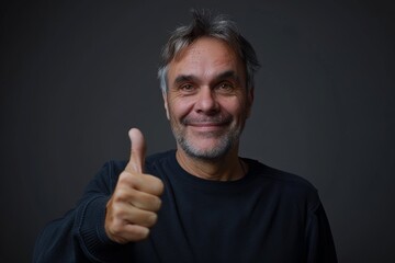 Wall Mural - Portrait of a satisfied man in his 50s showing a thumb up isolated in blank studio backdrop