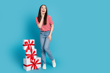 Wall Mural - Full length photo of adorable excited girl wear striped t-shirt choosing presents empty space isolated blue color background