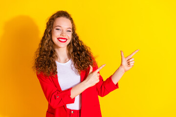 Wall Mural - Portrait of gorgeous young lady point fingers empty space wear red suit isolated on yellow color background