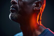 © Sergio - Close-up of African American older man's face lit by warm light, neck pain