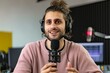 © alisaaa - Portrait of a young man talking on the microphone at the radio station