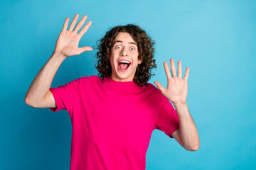 Sticker - Photo of nice young man raise hands open mouth wear pink t-shirt isolated on blue color background