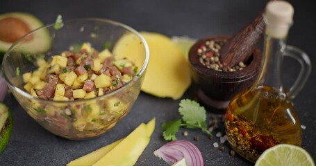 Canvas Print - Cooking traditional tuna and mango tartare - chopped and mixed tuna, mango, cilantro and onion in a glass bowl