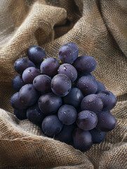 Poster - A bunch of fresh purple grapes on a burlap fabric.