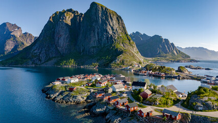 Wall Mural - An aerial view of a picturesque village in Norway, situated on a small island surrounded by stunning mountains and clear blue waters. Hamnoy Lofoten Norway