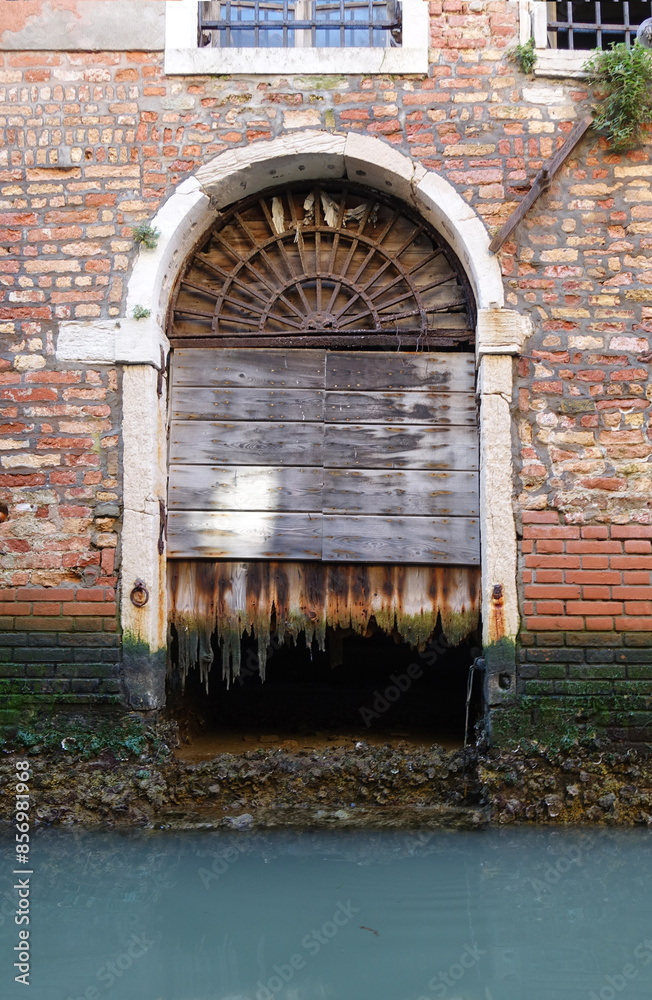 Old dilapidated door on the canal of Venice 