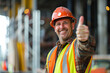 © johnalexandr - Smiling builder showing thumbs up on construction site background