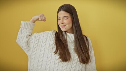 Sticker - Strong and beautiful, portrait of a young hispanic woman showing off powerful arm muscles while standing against a sunny yellow wall, embodying the athletic lifestyle