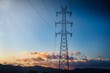 © Aloshin Evgeniy - Sunset or sunrise silhouettes a high-voltage power tower against colorful skies, with mountains in the backdrop adding depth to the scenic beauty.