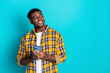 Photo of positive nice man wear trendy clothes buy modern device look empty space isolated on cyan color background