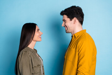 Wall Mural - Profile portrait of two young people look each other wear shirt isolated on blue color background