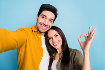 Wall Mural - Photo of two nice young partners selfie okey symbol wear shirt isolated on blue color background
