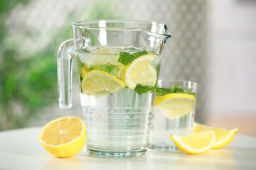 Sticker - Refreshing lemonade with mint in jug and glass on white table, closeup