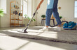 © Studio Romantic - Cropped photo of woman cleaning with vacuum cleaner carpet in the living room at home. Female janitor vacuuming the floor. Cleaning service, housekeeping, housework and household concept.