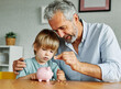 © Lumos sp - child money saving grandfather family coin senior finance bank piggybank happy investment grandson boy financial elderly cash