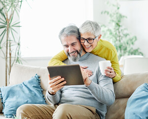 Wall Mural - woman couple senior man happy internet love tablet together mature active elderly retirement computer technology online using caucasian home adult family romance