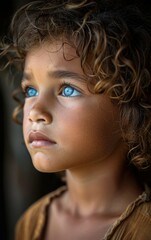 Poster - A young girl with brown hair and blue eyes. She has a light blue shirt on. She is looking at the camera