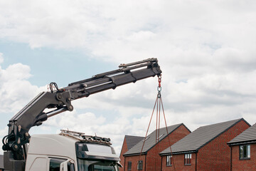 Wall Mural - Crane Lifting Materials at New Construction Site on Cloudy Day