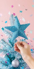 Poster - Serene Festive Scene with Hand Placing Blue Star Topper on Christmas Tree, Elegant Pastel Studio Background