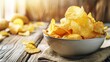 © iVGraphic - Bowl of crispy potato chips on rustic wooden table, snack food concept